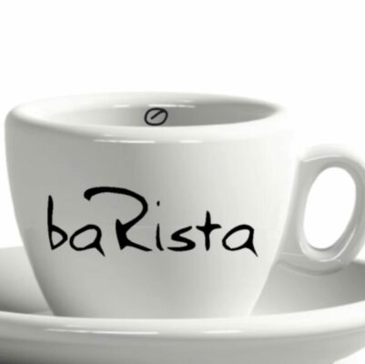Weiße Kaffeetasse auf Untertasse aus Keramik, mit dem Wort „Barista“, kreativ gestaltet mit einem Espressotassen-Symbol als Punkt über dem Buchstaben „i“.