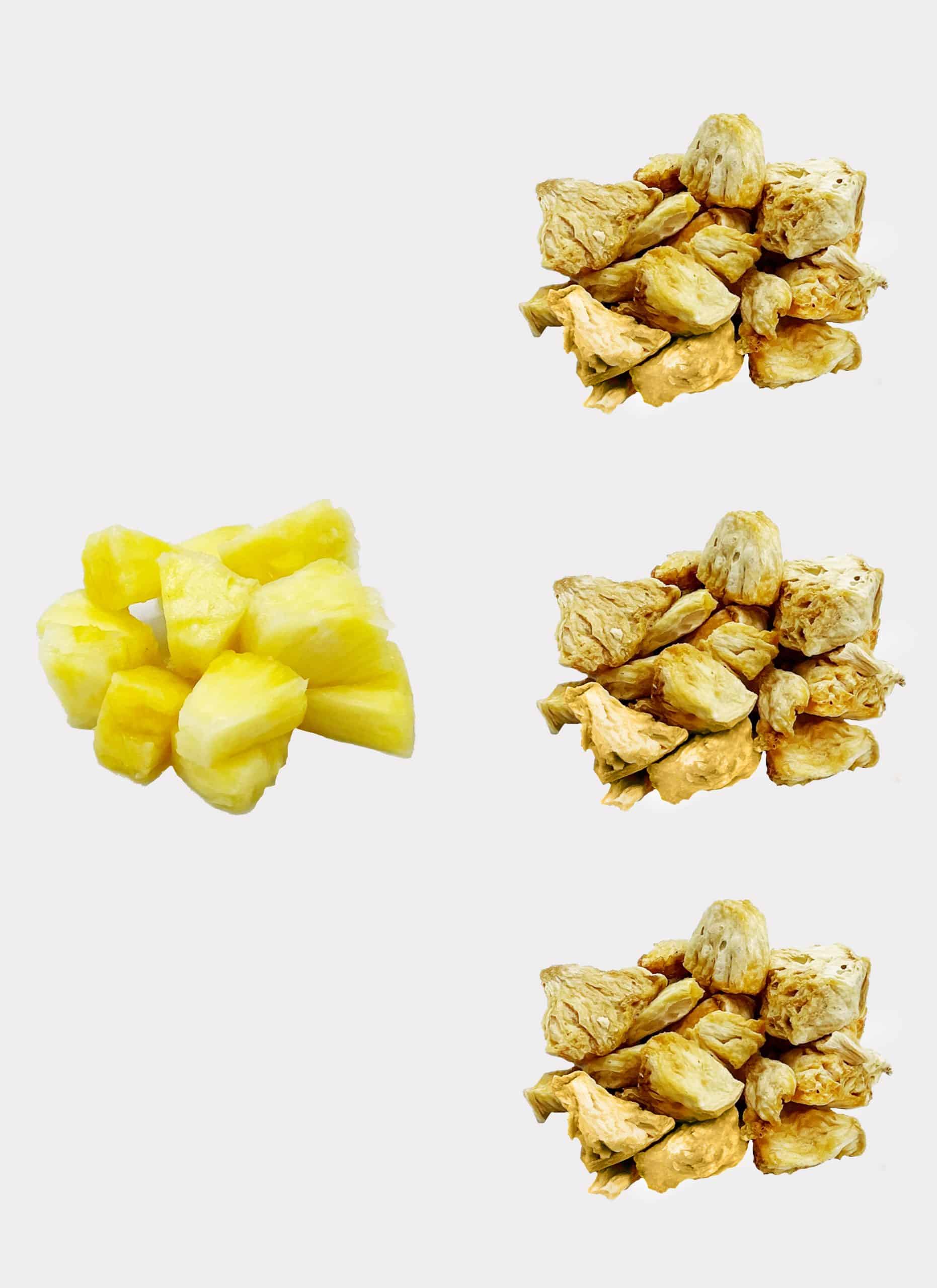 Links sind frische Ananasstücke und rechts drei Stapel gefriergetrockneter Ananas vertikal vor einem weißen Hintergrund angeordnet.