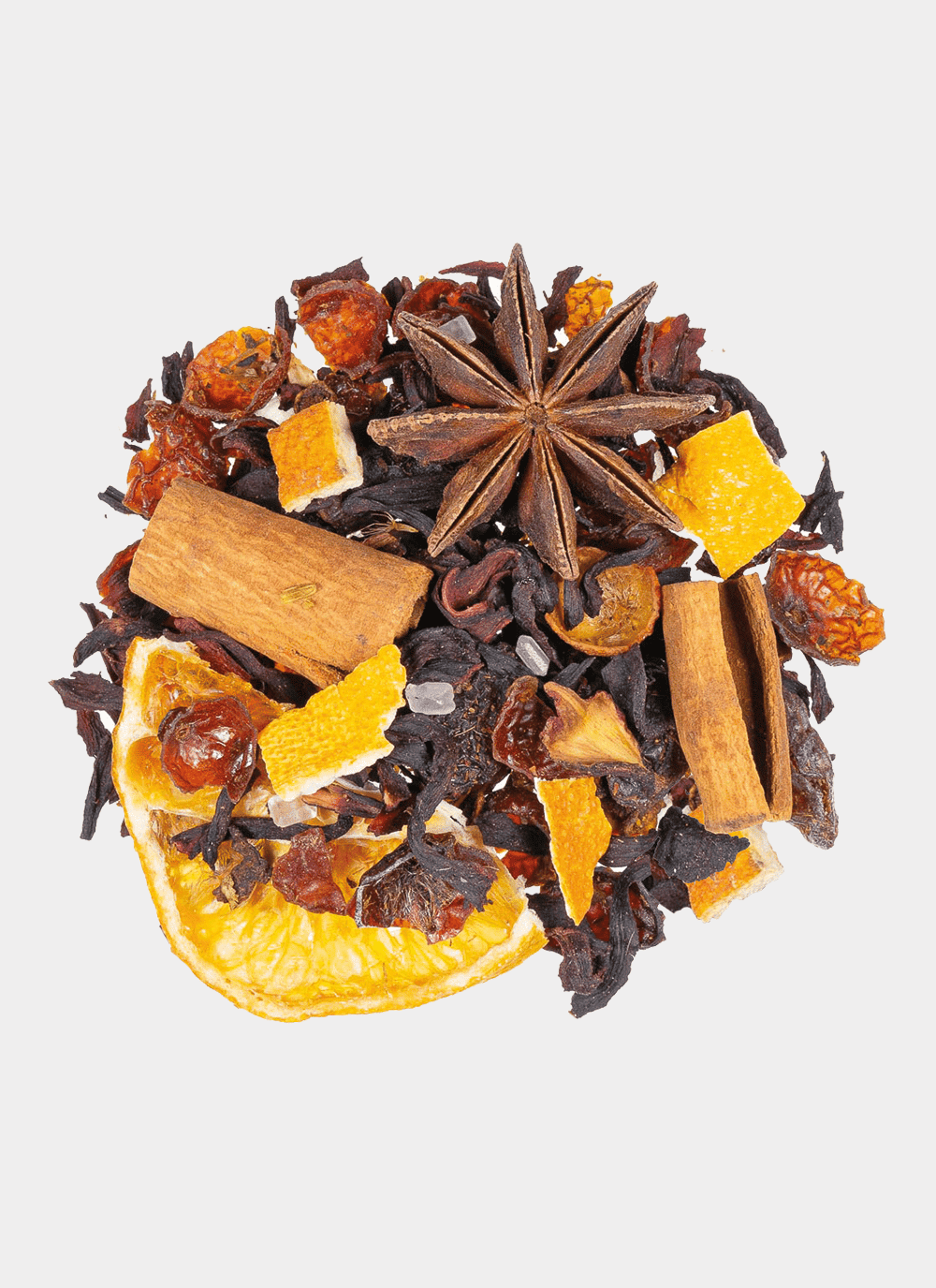 Eine Auswahl getrockneter Zutaten, darunter Orangenscheiben, Sternanis, Zimtstangen sowie verschiedene Kräuter und Gewürze aus der X-MAS BOX – 4 x 50 g Weihnachts-Tee, wird kunstvoll auf einem weißen Hintergrund präsentiert, um die Weihnachtsstimmung einzufangen.