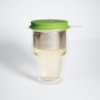 Ein transparentes LOFTEA Doppelwand-Glas enthält hellen Tee mit einem Edelstahl-Sieb und einem grünen Silikondeckel. Auf dem Sieb ist das Wort LOVEKA zu sehen, was es zu einer eleganten Ergänzung für jedes Tee-Set macht.
