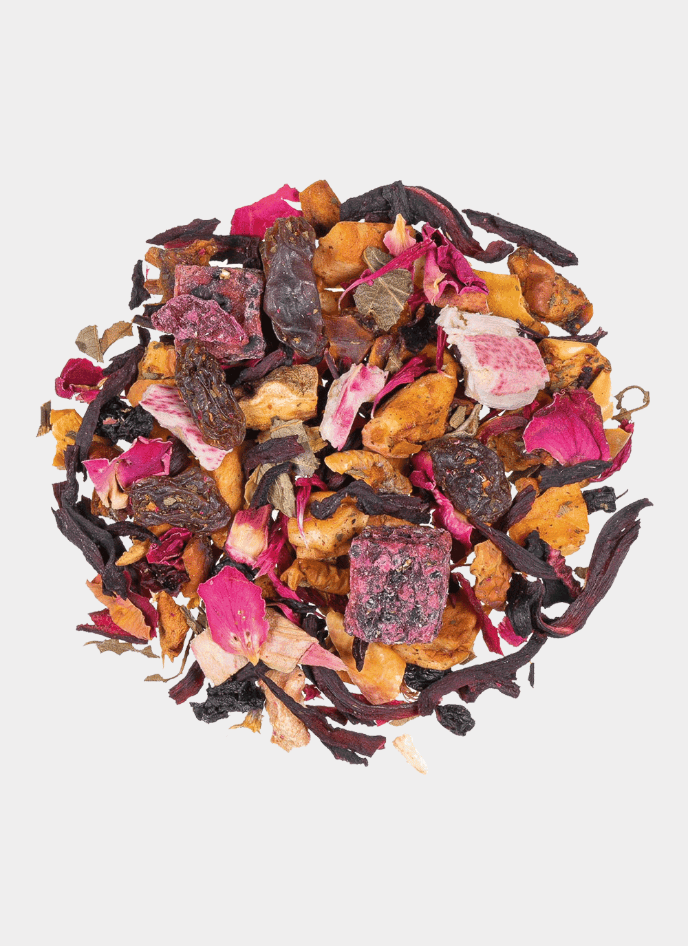 Eine lebendige Mischung aus getrockneten Teeblättern, Blütenblättern und Fruchtstücken auf weißem Hintergrund. Diese Mischung zeigt Schattierungen von Rot, Rosa, Orange und Braun mit subtilen Anklängen der IDA ROSE-Blütenblätter für einen strukturierten und farbenfrohen Look.