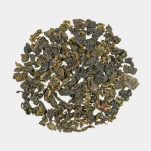 Eine runde Präsentation von losem Milky Oolong-Tee zeigt dunkelgrüne und braune gekräuselte Blätter, die vor einem schlichten weißen Hintergrund ein subtiles Milcharoma verströmen.